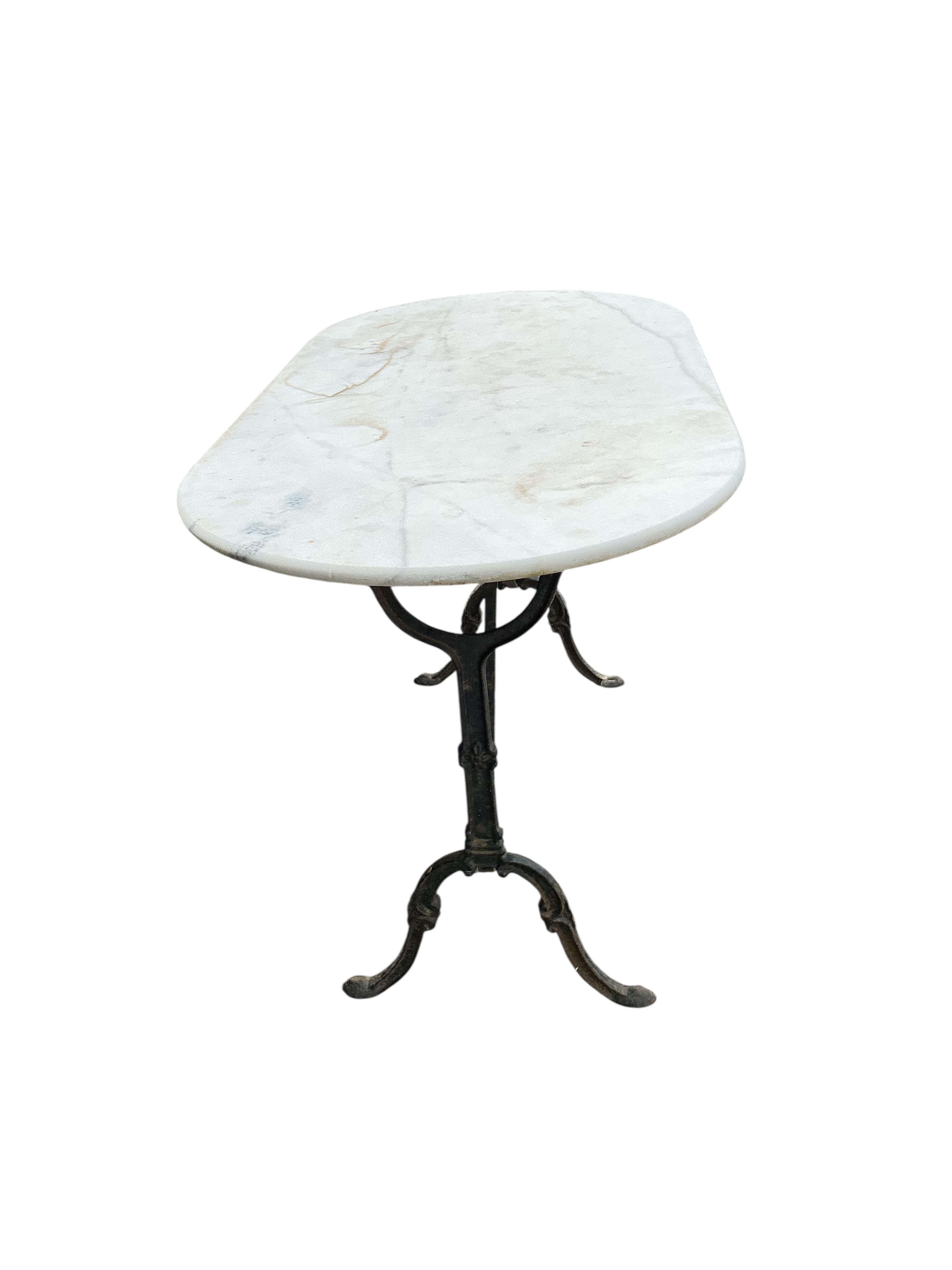 An oval reconstituted marble and cast iron garden table, width 120cm, depth 60cm, height 71cm